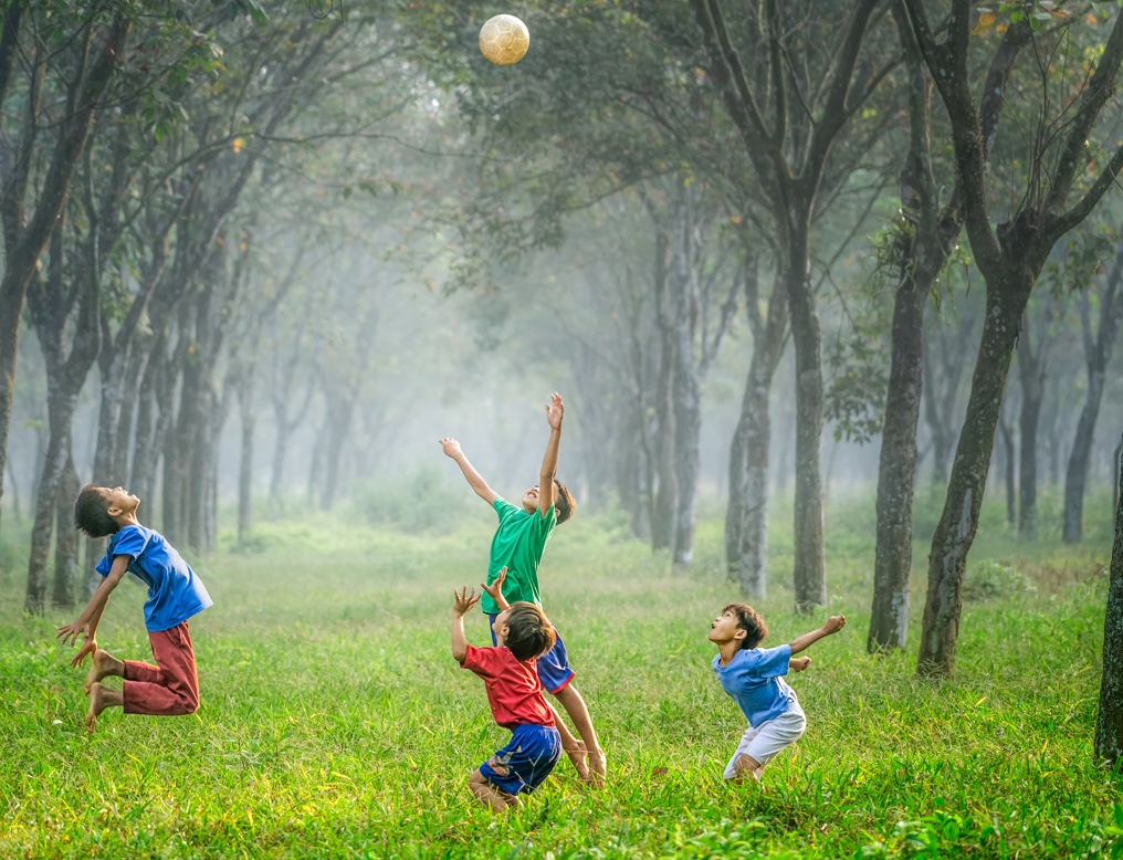 Children playing outside with a soccer ball
